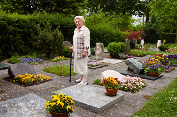 Alte Frau auf einem Friedhof