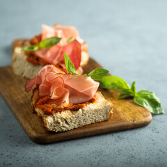 Homemade bruschetta with smoked meat and red pesto