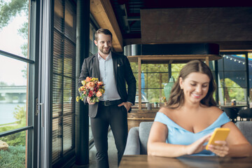 Woman sitting waiting and walking man with flowers