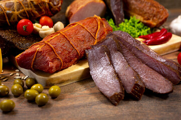 Assortment of cold cuts, a variety of processed cold meat products. On a wooden background