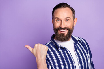 Photo of promoter positive guy direct thumb empty space wear striped shirt isolated violet color background
