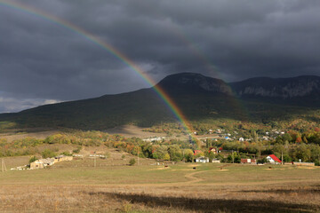 Beautiful rural landscape in Crimea with a rainbow in the sky after rain
