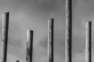 Abstract black and white pillars against cloudy sky