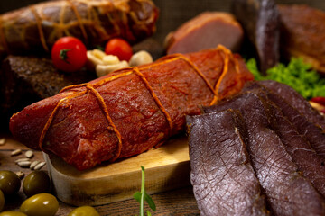 Assortment of cold cuts, a variety of processed cold meat products. On a wooden background