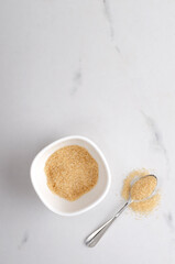 Vertical image.Top view of bowl full of brown sugar and spoon on the kitchen table