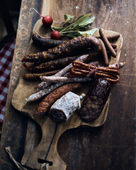 Appetizing meat delicatessens on chopping board with radishes