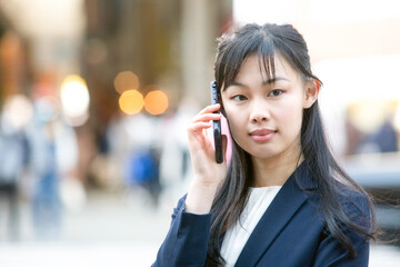 屋外で携帯電話で通話する女性