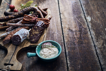 Appetizing meat delicatessens with soft cheese in bowl