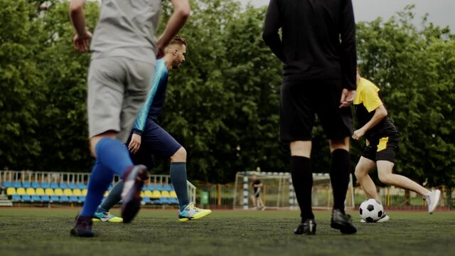 Friends play soccer with each other. Football amateur game in a small stadium. Workout training. Team friendly match. Sport