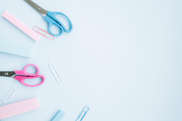 School stationery and supplies on blue background with space for caption. Back to school, online school. Minimalistic set of colorful stationery. Flat lay