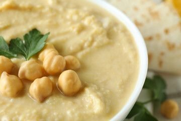 Bowl of hummus with chickpea and parsley, close up