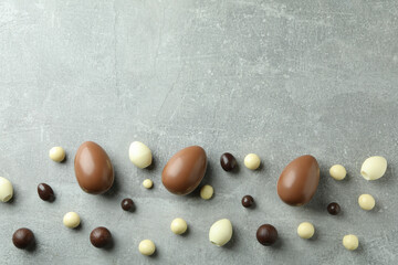 Easter chocolate eggs and candies on gray background