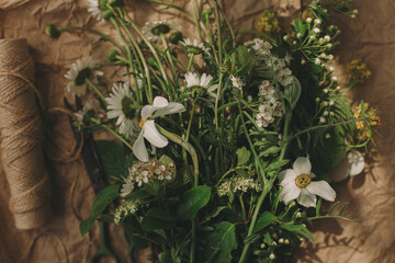 Beautiful daffodils and wildflowers in sunny light on rustic paper. Spring flowers rural still life