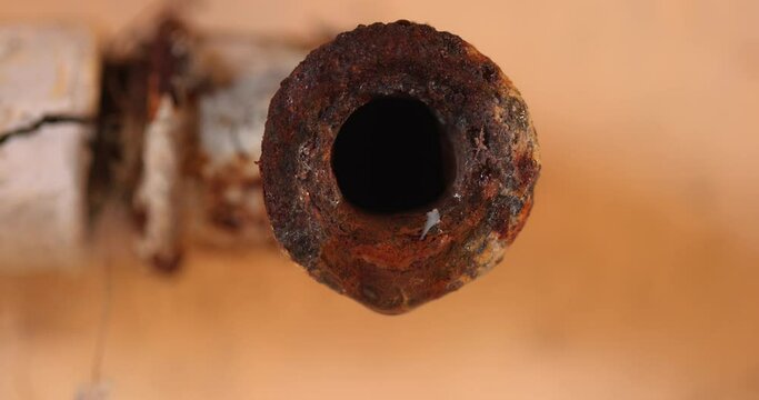 Water leaking from corroded pipe closeup footage