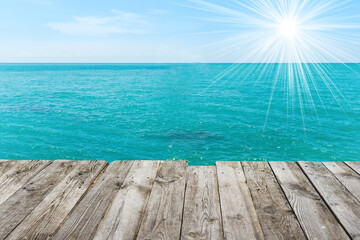 Naklejka na ściany i meble Blue sea with sun, water summer background, view from wooden table