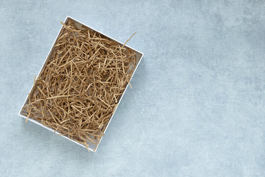 Empty gift box mockup for eco gift filled with decorative shredded paper on gray background