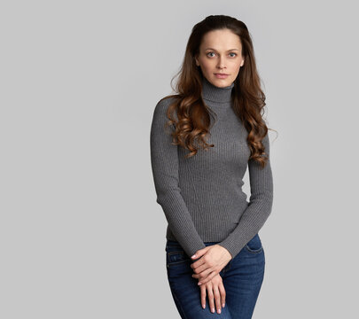 Young Woman With Long Brown Hair Is Wearing Grey Sweater