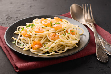 Close-up spaghetti shrimp scampi with in a plate on dark backdrop