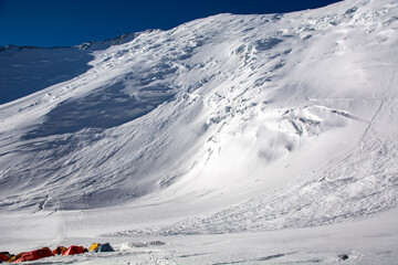 high camp in high altitude mountains with huge avalanche coming to tents 