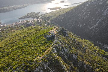 Aerial drone shot of City Wall of Ston over hill to Mali Ston in Croatia summer morning sunrise