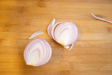 Cut the red onion in half on a wooden board.How to cut onions without crying. How to grow onions in the garden.