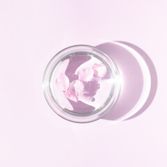 Floating soft pink rose petals in aromatherapy bowl with water. Top view minimal concept. Sun and shadows. Pastel background.