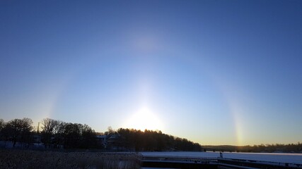 It is dawn and the sun has just risen over the frozen lake
