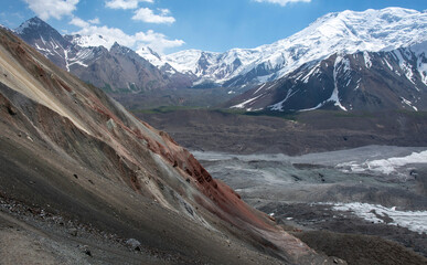 glacier in the mountains with red rock mountains and high peak range panorama 