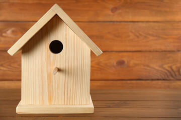 Beautiful bird house on wooden table, space for text