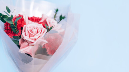 A beautiful bouquet of red and pink roses against a blue background. Holiday gift valentine day, 14 february, March 8, Mothers day