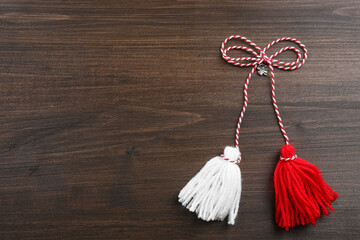 Traditional martisor on wooden background, top view with space for text. Beginning of spring...