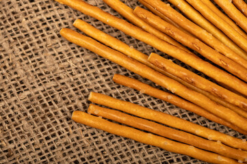 Salty bread strips scattered on a background of coarse homespun fabric.