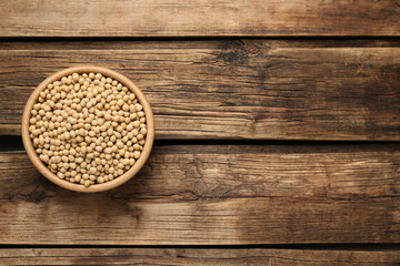 Soy in bowl on wooden table, top view. Space for text
