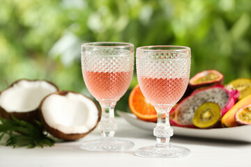 Delicious exotic fruits and wine on white table
