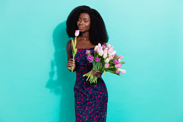 Photo portrait woman with closed eyes smelling enjoying tulip flower scent in spring isolated on bright turquoise color background