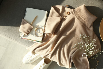 Soft cashmere sweater and accessories on sofa, flat lay