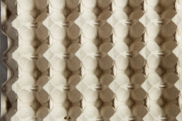 Back of a large empty egg carton. Abstract rhombuses with geometric shapes pattern as a textured background. Food packaging.