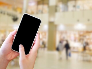 ショッピングモールで携帯電話を触る女性