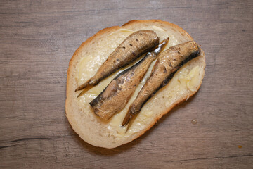 Sandwich with sprats on wooden background. Tasty sprats on bread. Sprats Made in Latvia.