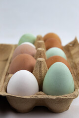 Green, brown and white eggs in a egg box