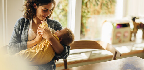 Loving mother feeding baby son with bottle