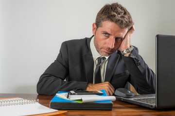 upset and depressed businessman at office desk - young unhappy man working frustrated suffering stress and depression as employee of corporate business