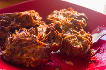 Fried vegetable fritters with zucchini, carrots, herbs, eggs, and cheese.