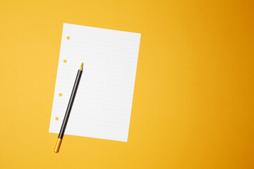 Sharpened wooden yellow color pencil with black body color on the notebook lined paper sheet with the space copy text on the bright solid yellow fond background - Powered by Adobe