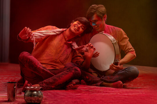 HAPPY YOUNG MEN ENJOYING HOLI FESTIVAL TOGETHER BY PLAYING DAFLI	