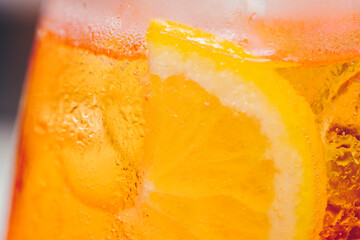 Glass of ice cold Aperol spritz cocktail served in a wine glass, decorated with slices of orange....