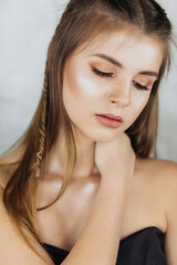 Fashion model portrait Beautiful brunette on a light background with closed eyes, portrait of a girl with make-up.