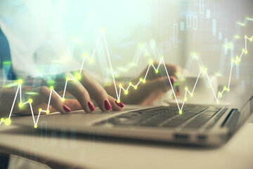 Multi exposure of woman hands typing on computer and financial graph hologram drawing. Stock market analysis concept.