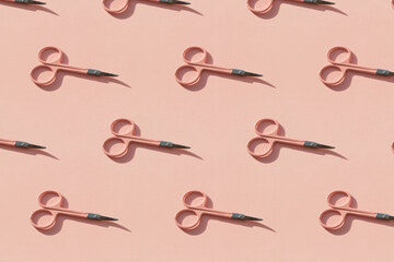 Cosmetic scissors on pink background.