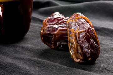 Big luxury dried date fruit on the dark surface, kurma ramadan kareem concept, close up.